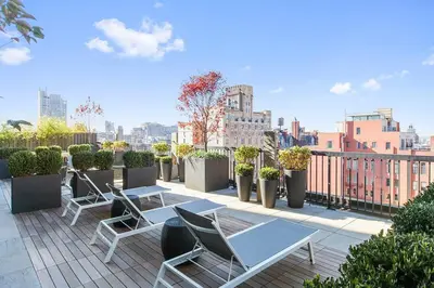 a patio with chairs and a table on a rooftop at Blueground Chelsea fitness center nr Madison Square Park NYC-390 in New York