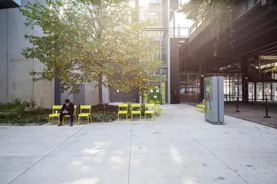 a person sitting on a chair under a tree in a building at Blueground Chelsea fitness center nr Madison Square Park NYC-390 in New York