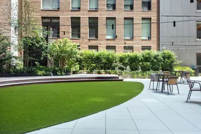 a garden with a lawn and tables and chairs at Blueground Chelsea rooftop pool nr High Line NYC-2145 in New York