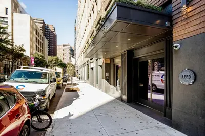 a street with cars parked next to a building at Blueground Chelsea pool nr The Vessel NYC-2144 in New York