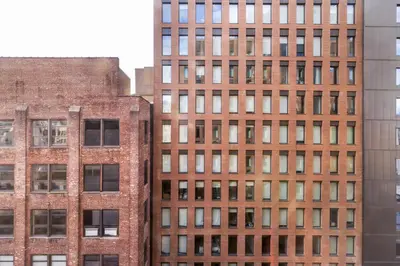 a tall brick building with many windows at Blueground Chelsea pool nr The Vessel NYC-2144 in New York