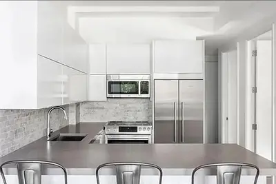 a kitchen with white cabinets and stainless steel appliances at Residence Heritage Terrace Dreaming in New York