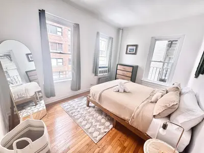 a bedroom with a large bed and two windows at Upper East Side 2Bed Dream in New York