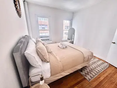 a large bed in a bedroom with a window at Upper East Side 2Bed Dream in New York