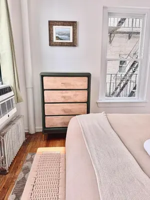 a bedroom with a bed and a dresser and a window at Upper East Side 2Bed Dream in New York