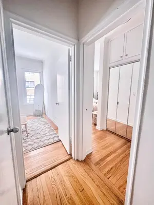an open door to a room with white walls and wood floors at Upper East Side 2Bed Dream in New York