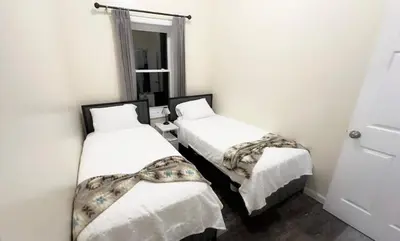 two beds in a room with white walls at Bright Spacious 3-Bed Ideal, Sightseeing & Comfort in Elizabeth