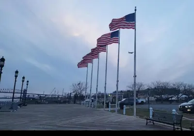 a row of american flags on poles in a parking lot at Bright Spacious 3-Bed Ideal, Sightseeing & Comfort in Elizabeth