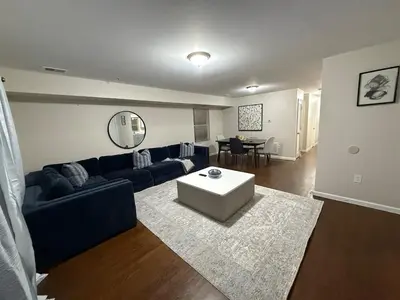 a living room with a blue couch and a table at COZY 3 bedroom APT near EWR Downtown NYC in Newark