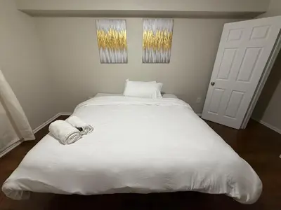 a bedroom with a large white bed with towels on it at COZY 3 bedroom APT near EWR Downtown NYC in Newark
