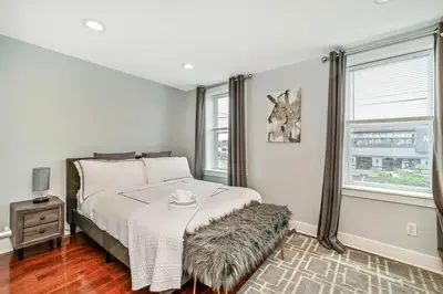 a white bedroom with a bed and a window at Outstanding Home Relaxing Rooftop with Patio & Grill in Philadelphia