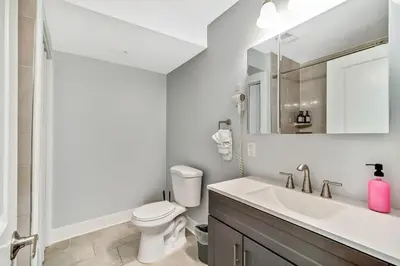 a white bathroom with a toilet and a sink at Outstanding Home Relaxing Rooftop with Patio & Grill in Philadelphia