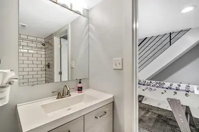 a white bathroom with a sink and a mirror at Outstanding Home Relaxing Rooftop with Patio & Grill in Philadelphia