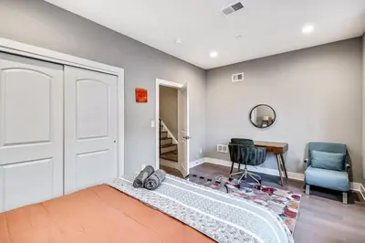 a bedroom with a bed and a chair and a door at Exceptional Downtown Townhome with Roof Deck -4Bedroom & 3Baths in Philadelphia