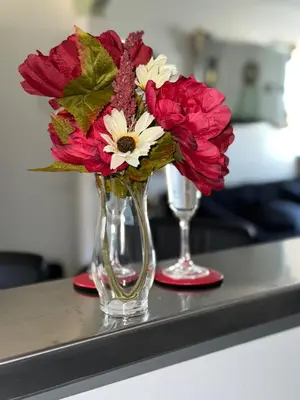 a vase with red and white flowers on a counter at Professional & Student-Friendly in Upper Darby