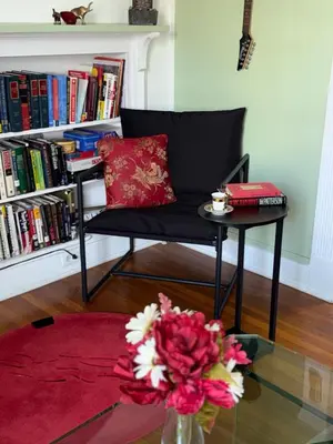 a living room with a chair and a table and a vase with flowers at Professional & Student-Friendly in Upper Darby