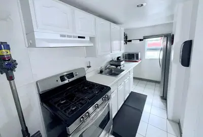 a small kitchen with a stove and a sink at Professional & Student-Friendly in Upper Darby