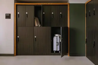 a locker room with brown doors with auggage at Sosuite at The Queen - Queen Village in Philadelphia