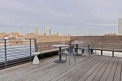 a patio with two tables and chairs on a roof at Sosuite at The Queen - Queen Village in Philadelphia