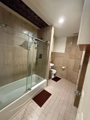 a bathroom with a shower and a tub and a toilet at Hudson Yard 4 in New York