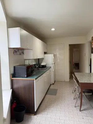 a kitchen with white cabinets and a table and a microwave at Hudson Yard 4 in New York