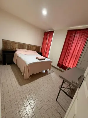 a bedroom with a bed and red curtains and a chair at Hudson Yard 4 in New York
