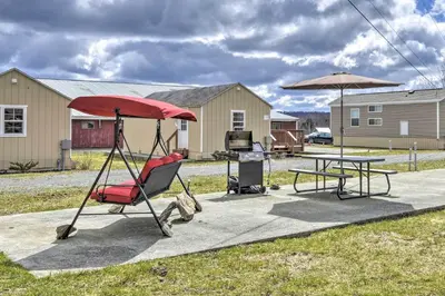 a patio with a table and a chair and an umbrella at Country Escape near Camps & Ski in Pleasant Mount