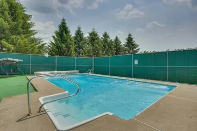 a large swimming pool with a green fence at Country Escape near Camps & Ski in Pleasant Mount