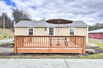 a house with an umbrella on a wooden deck at Country Escape near Camps & Ski in Pleasant Mount