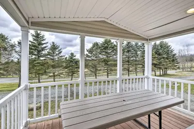a wooden porch with a bench on a deck at Woodland Hideout near Ski Adventures in Pleasant Mount