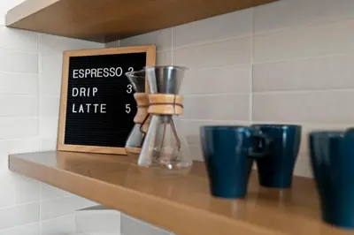a wooden shelf with a drink dispenser and blue cups at Bright 2-Bed Loft in Northern Liberties Walk to Dining, Museums in Philadelphia