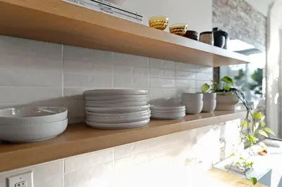 a shelf with plates and bowls on it in a kitchen at Bright 2-Bed Loft in Northern Liberties Walk to Dining, Museums in Philadelphia