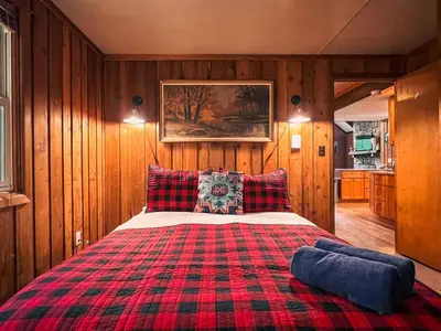 a large bed in a room with wooden walls at Gorgeous Chalet in the Poconos w/ Hot Tub! in Locust Lakes Village
