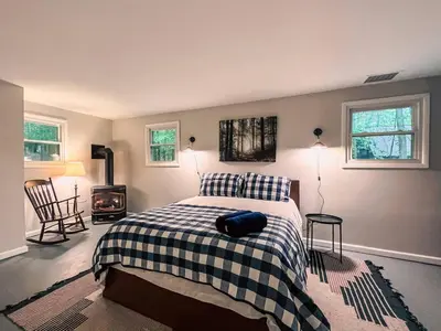 a bedroom with a bed with a black and white blanket at Gorgeous Chalet in the Poconos w/ Hot Tub! in Locust Lakes Village