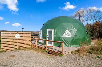 a green dome tent sitting on a wooden deck at Barrel Hot Tub at 'The Eagle Dome' in Franklin in Franklin