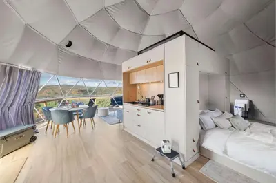 a bedroom with a bed and a kitchen with a table at Barrel Hot Tub at 'The Eagle Dome' in Franklin in Franklin