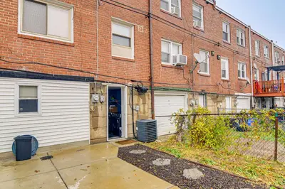 a brick building with a garage in front of it at Pet Friendly! NW Philly Rowhouse with Fenced Yard! in Philadelphia