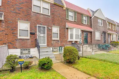 a brick building with a fence and a yard at Pet Friendly! NW Philly Rowhouse with Fenced Yard! in Philadelphia