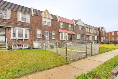 a row of brick houses with a fence at Pet Friendly! NW Philly Rowhouse with Fenced Yard! in Philadelphia