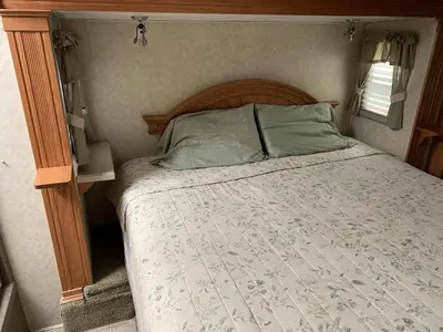 a bed with a wooden headboard in a bedroom at Jellystone Park PA Wilds in Mansfield