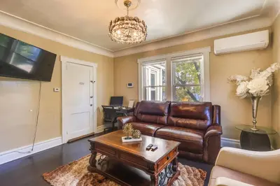 a living room with a leather couch and a table at Easy Commute to Newark and NYC! Extended Stay Unit in Irvington