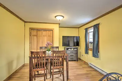 a dining room with a table with chairs and a television at Cottages and Suites near Ski Slopes in Pleasant Mount