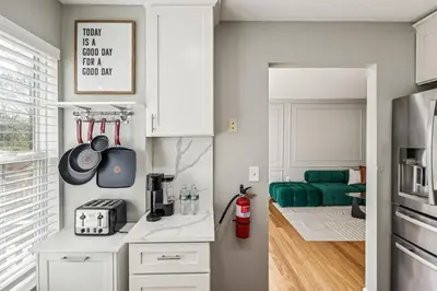 a kitchen with white cabinets and a green couch at Spacious 3BR Near Rutgers plus Princeton plus NYC Access in Franklin Park