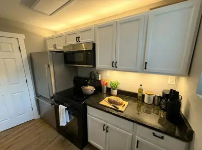 a kitchen with white cabinets and a black stove top oven at Crossroads at Park Place in Wilmington