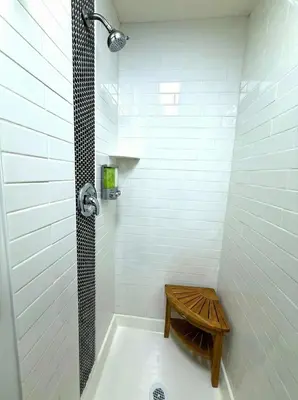 a bathroom with a tub with a wooden bench in it at Crossroads at Park Place in Wilmington