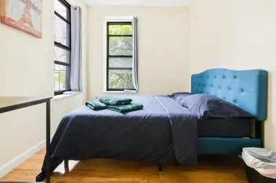 a bedroom with a blue bed and a blue chair at Spacious Central Park Apartments in New York