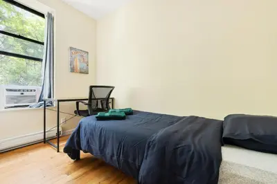 a bedroom with a bed and a window at Spacious Central Park Apartments in New York