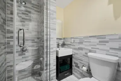 a bathroom with a toilet and a sink and a shower at Spacious Central Park Apartments in New York