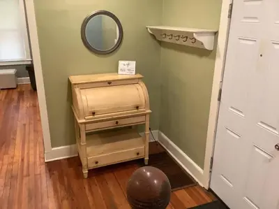 a small wooden dresser with a mirror next to a door at Inviting, Calming PR -Lourdes Hospital Binghamton in Johnson City