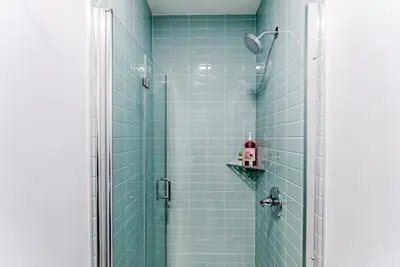a bathroom with a shower with blue tiles at Studio Minutes from Center City South Philly Special in Philadelphia